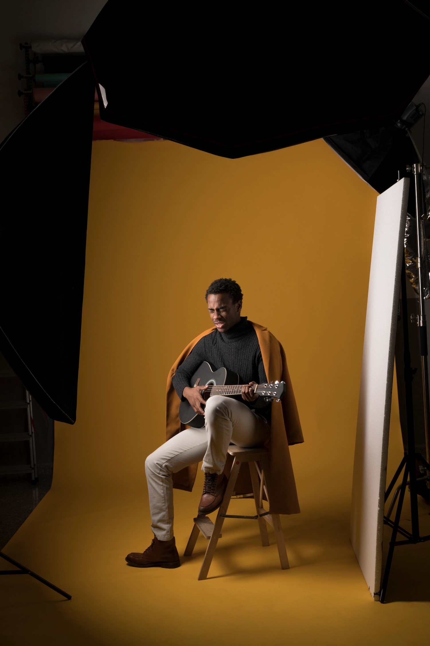 Dramatic studio environment with professional lighting casting golden shadows across photography equipment